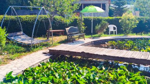 a garden with a swing and a pond at L'Orchidea in Sante Marie