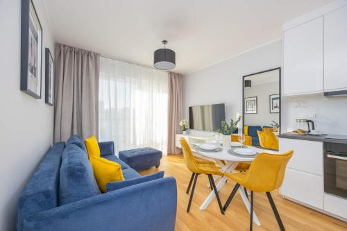 a living room with a blue couch and a table at Elegant Apartment in Warsaw with Parking and Desk for Remote Work by Noclegi Renters in Warsaw