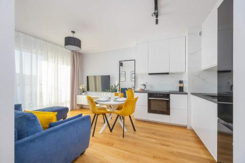 a kitchen and a living room with a table and chairs at Elegant Apartment in Warsaw with Parking and Desk for Remote Work by Noclegi Renters in Warsaw