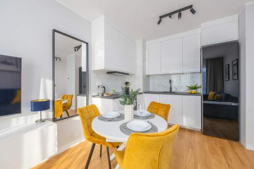 a kitchen and dining room with a table and chairs at Elegant Apartment in Warsaw with Parking and Desk for Remote Work by Noclegi Renters in Warsaw