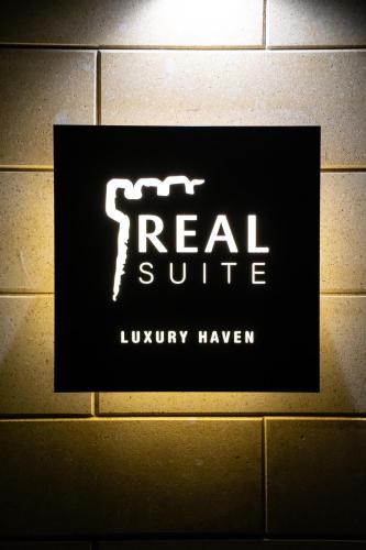 a sign for a real suite on a wall at Real suite spa in Palermo