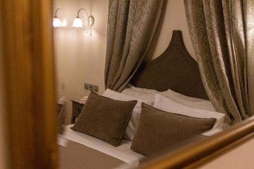 a reflection of a bed with pillows in a mirror at April Medieval Hotel in Rhodes Town