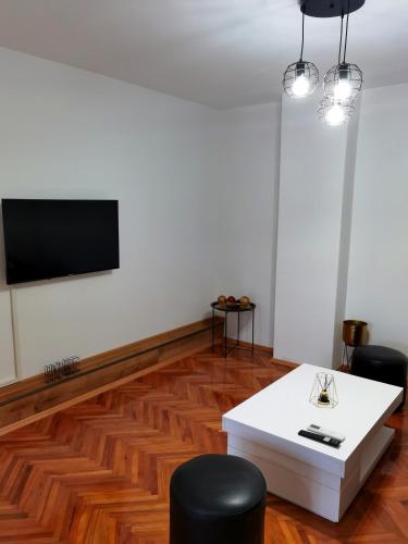 a living room with a white table and black chairs at Vila Nika in Banja Luka
