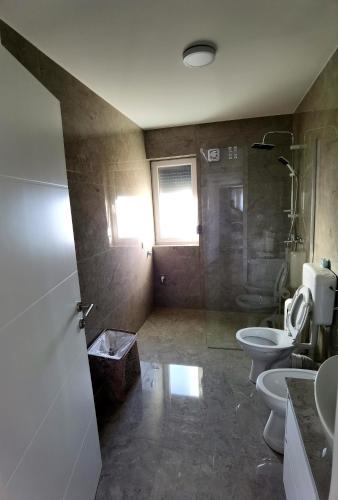 a bathroom with two toilets and a glass shower at Vila Nika in Banja Luka