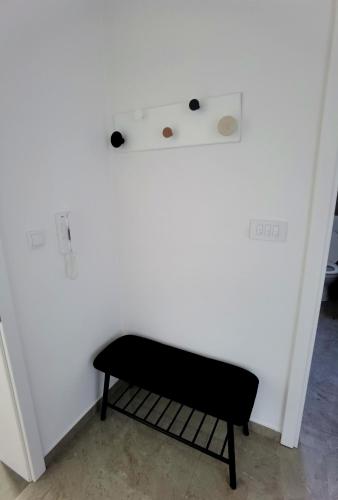 a black bench in a room with a white wall at Vila Nika in Banja Luka