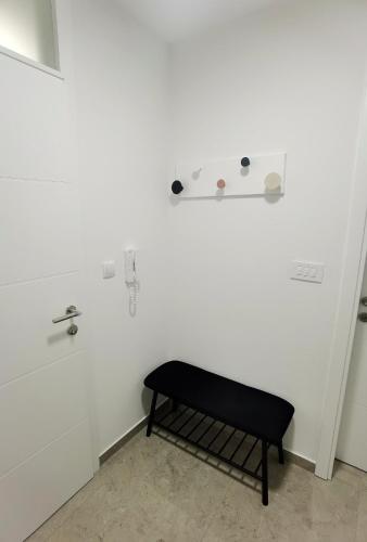 a black bench in a room with a white wall at Vila Nika in Banja Luka