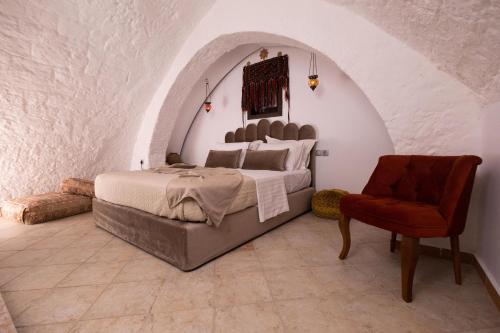 a bedroom with a bed and a chair at April Medieval Hotel in Rhodes Town