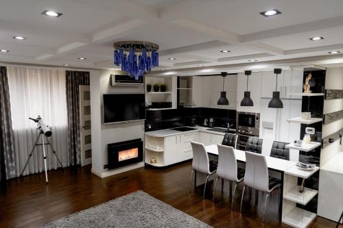 a kitchen with a table and chairs and a fireplace at Apartment in Călărași in Călăraşi