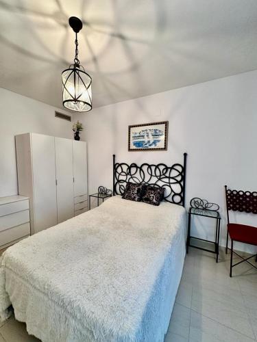 a bedroom with a large bed and a chandelier at Villa Martina in Cambrils