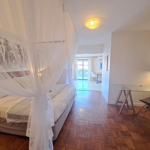 a bedroom with a bed with a white canopy at Joli Guesthouse in Maputo