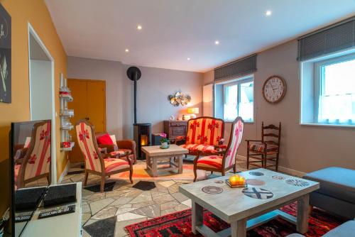 un salon avec des chaises rouges et une table dans l'établissement Hon Ty Glas - Maison proche de plage avec jardin, à Moëlan-sur-Mer