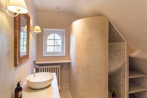une salle de bain avec un lavabo et un miroir dans l'établissement Ker Val - Belle maison avec jardin proche plage, à Pléneuf-Val-André