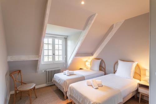 deux lits dans une chambre avec deux fenêtres dans l'établissement Ker Val - Belle maison avec jardin proche plage, à Pléneuf-Val-André