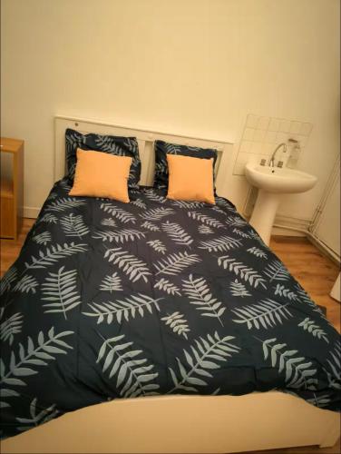 - un lit avec une couverture noire et blanche et un lavabo dans l'établissement T5 Place république Rennes, à Rennes