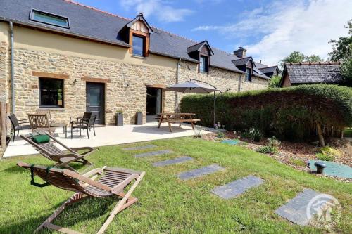 a yard with chairs and tables and a building at Tuberix in Ercé-près-Liffré