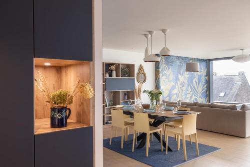 une salle à manger et un salon avec une table et des chaises dans l'établissement La Briouette - Magnifique appartement avec vue panoramique d'exception sur la baie du Val André, à Pléneuf-Val-André