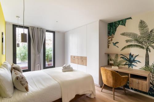 プレヌフ・ヴァル・アンドレにあるLa Briouette - Magnifique appartement avec vue panoramique d'exception sur la baie du Val Andréの大きなベッドと机のある寝室