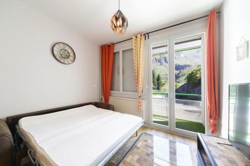 a bedroom with a bed and a large window at Ô Cocon - Station de ski à pied vue montagne in Eaux-Bonnes