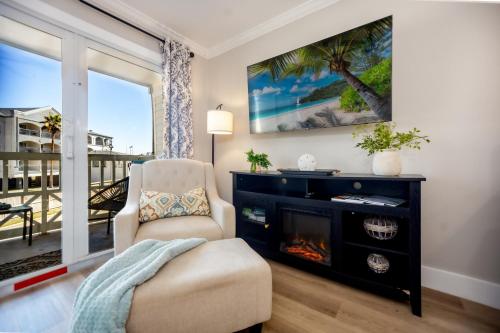 a living room with a fireplace and a chair at Sea-Renity Heated pools steps to the beach in Galveston