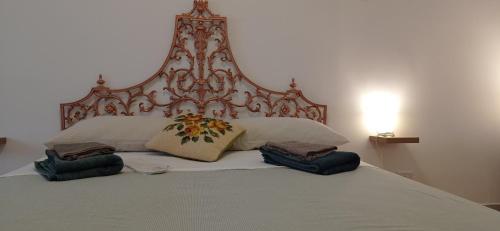 un grande letto con due cuscini e una testiera di Appartamento Levante a Bari