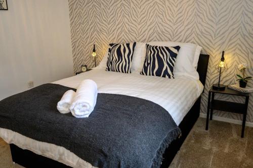 a bedroom with a bed with towels on it at Vinmar Very Special Bungalow In Charming Area Of Wales By StayStaycations in Pengam