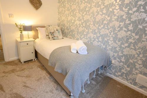 a bedroom with a bed with two towels on it at Vinmar Very Special Bungalow In Charming Area Of Wales By StayStaycations in Pengam