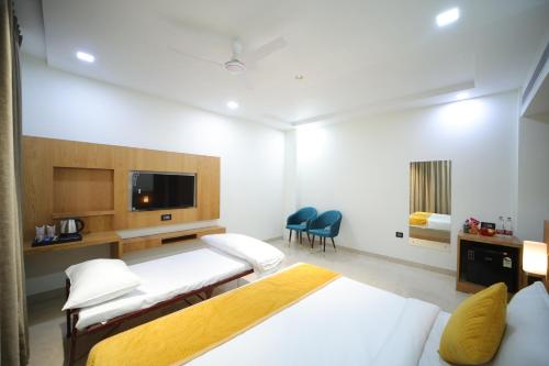 a hotel room with two beds and a tv at Hotel The RS Casa - Agra in Agra