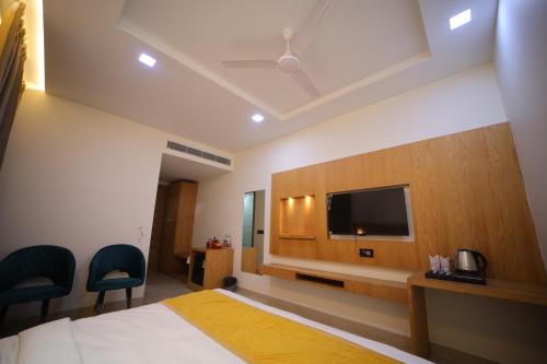a hotel room with a bed and a flat screen tv at Hotel The RS Casa - Agra in Agra