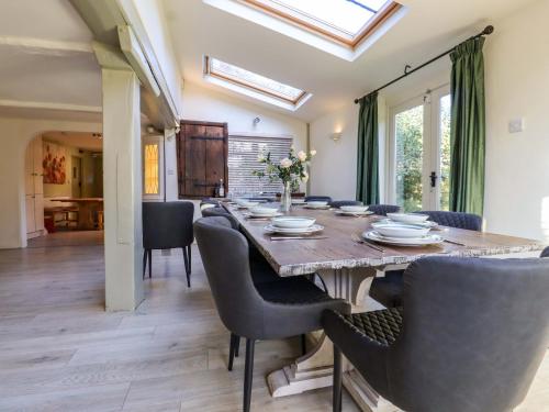 a dining room with a wooden table and chairs at Golford Cottage in Cranbrook