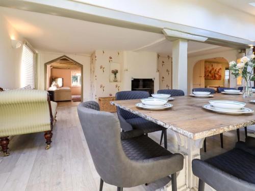 a dining room with a wooden table and chairs at Golford Cottage in Cranbrook