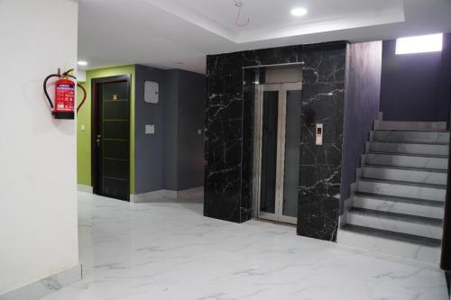 a hallway with black marble walls and stairs at Hotel Aastha Height in Rishīkesh