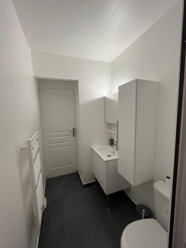 une salle de bain blanche avec des toilettes et un lavabo dans l'établissement Appartement Caroline Proche mer & ville CALVI, à Calvi