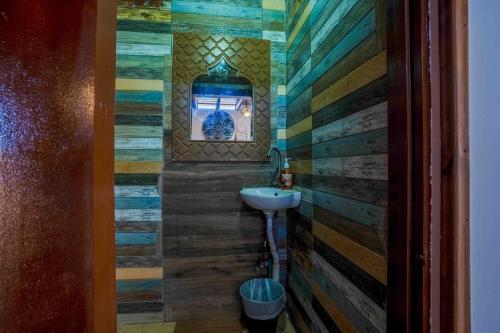 a bathroom with a sink and a wooden wall at Dream Catcher in Dahab