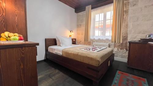 a bedroom with a bed with a bowl of fruit at Stara Čaršija Hotel & SPA in Bar
