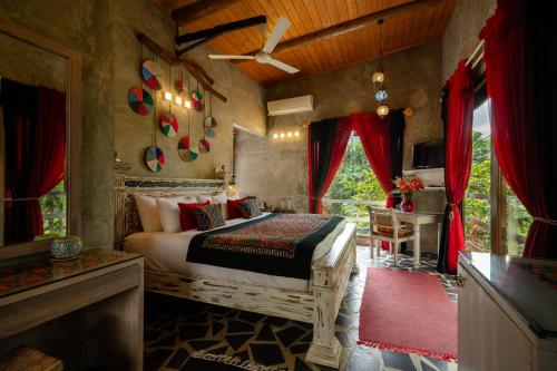 a bedroom with a bed in a room with red curtains at Aathma Colombo House in Colombo