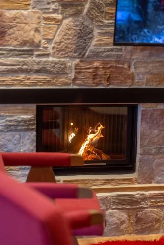 a brick fireplace with a fire in it at Vila 66 in Korçë