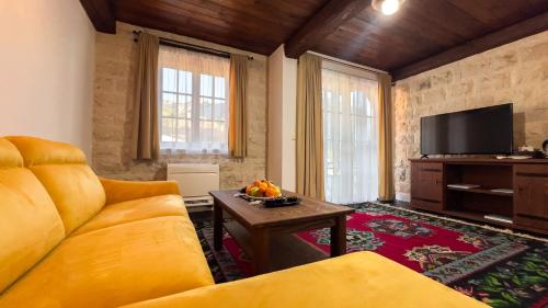 a living room with a couch and a tv at Stara Čaršija Hotel & SPA in Bar