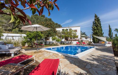 a swimming pool in a villa with an umbrella at Villa Pranayama in Santa Gertrudis de Fruitera