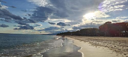 a beach with people walking on the sand and the water at Villa Martina in Cambrils
