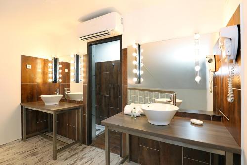 a bathroom with two sinks and two mirrors at Le Néliö in Aix-en-Provence