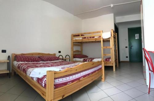 a bedroom with two bunk beds and a ladder at Casa Corti Ostello Ristorante in Valbondione