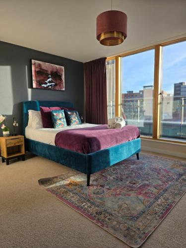 a bedroom with a bed and a large window at Stay Angels - Blonk Street Sheffield Luxury Apartments in Sheffield
