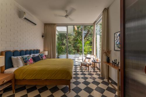 a bedroom with a king sized bed and a patio at La Masillia, 2 BHK with Private Pool, 15 mins from Morjim Beach, Wifi, Peaceful location, Kitchen, Security, Patio in Siolim