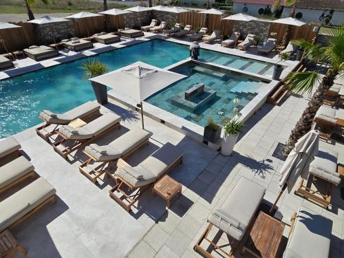 an overhead view of a swimming pool with chairs and an umbrella at Les Loges du Luberon in Coustellet