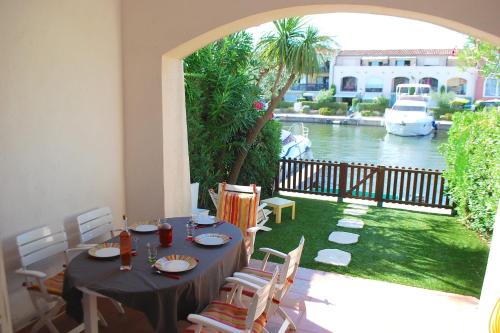 une table et des chaises avec vue sur une rivière dans l'établissement Fisherman house with WIFI and a mooring in a private area - parking near-by, à Grimaud