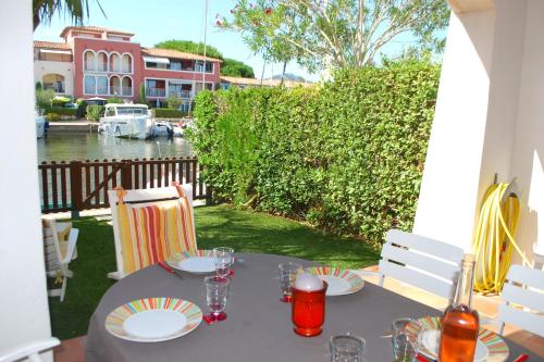 - une table avec des assiettes et des verres à vin sur la terrasse dans l'établissement Fisherman house with WIFI and a mooring in a private area - parking near-by, à Grimaud