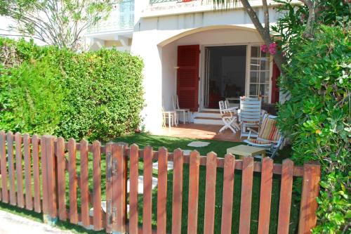 une clôture en bois devant une maison dans l'établissement Fisherman house with WIFI and a mooring in a private area - parking near-by, à Grimaud