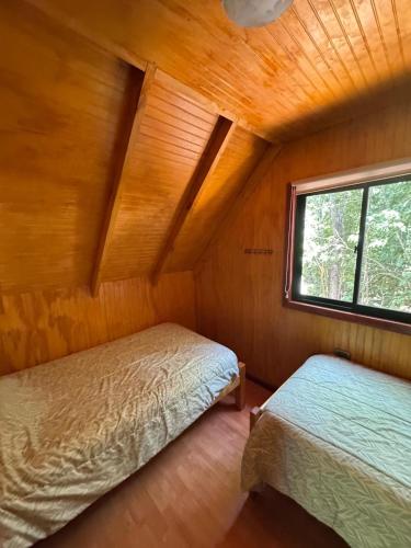 a bedroom with two beds in a room with a window at Cabañas El Mirador de Recinto in Recinto