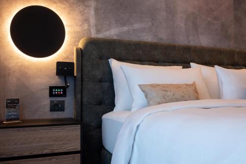 a bedroom with a bed and a clock on the wall at Hotel Simona Halep - Poiana Brasov in Poiana Brasov