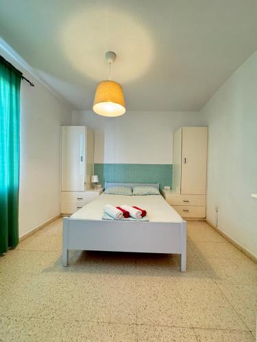 a bedroom with a white bed and a light at Magic Sea Apartments in Larnaka